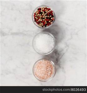 Salt and pepper on white marble background