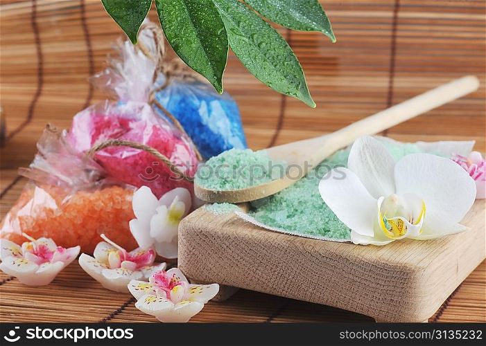 salt for bath, flower, candles on straw napkin