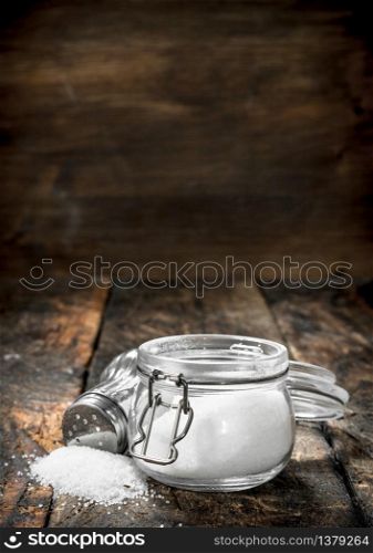 Salt in a glass jar. On wooden background.. Salt in a glass jar.