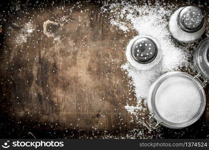 Salt in glass jar on a wooden table. On rustic background.. Salt in glass jar on a wooden table.