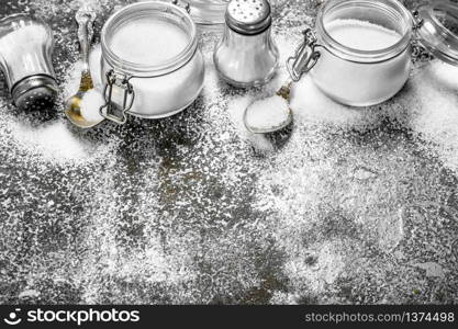 Salt in jars and spoons. On rustic background.. Salt in jars and spoons.