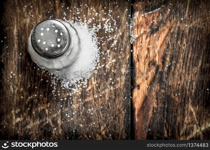 Salt in saltcellar. On wooden background. Salt in saltcellar.