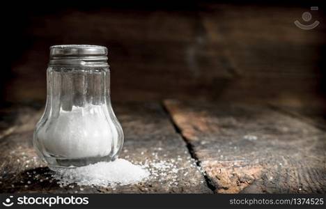 Salt in saltcellar. On wooden background. Salt in saltcellar.