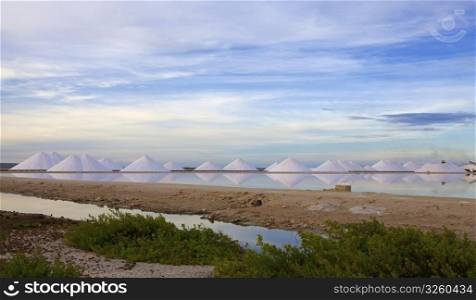 Salt mountains reflecting in the salt lake at Bonaire. Salt