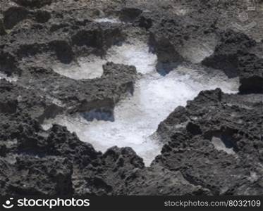 Salt precipitation in eroded black oxidized limestone cavities near Mediterranean sea. July, Can Pastilla, Mallorca, Balearic islands, Spain.