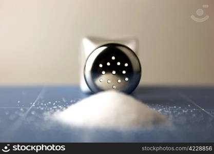 Salt shaker on wooden table.