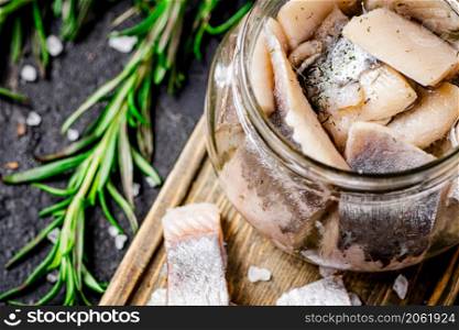 Salted herring glass jar. On a black background. High quality photo. Salted herring glass jar. On a black background.