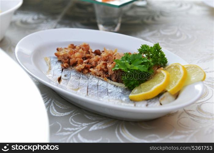 salted herring with fried onions and lemon on plate