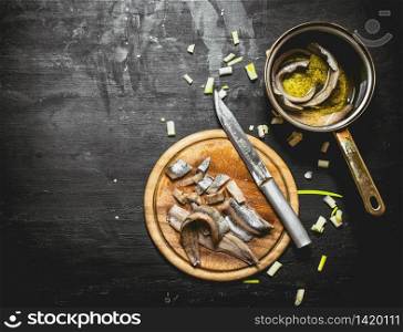 Salted herring with spices and herbs. Black chalkboard.. Salted herring with spices and herbs