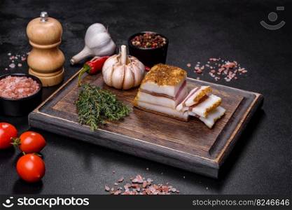 Salted Lard, Raw Pork with Spices on Wooden Cutting Board Studio Photo. Smoked lard, bacon, half a piece, on a wooden dark cutting board