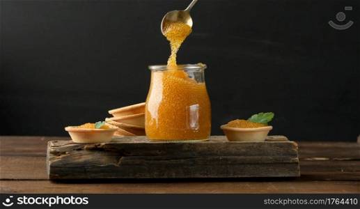 salted pike caviar in a glass jar on a wooden board