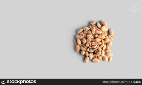 Salted pile of Peanuts in isolated over white textured background, top view, close-up.