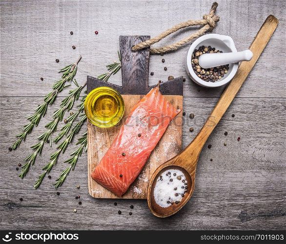 salted salmon fillet on a cutting board with delicious ingredients for cooking on wooden rustic background top view
