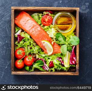 Salted salmon fillet with aromatic herbs. Salmon with vegetables and lettuce in box.Healthy eating