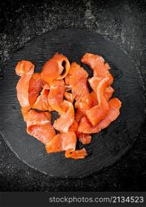Salted salmon on a stone board. On a black background. High quality photo. Salted salmon on a stone board.