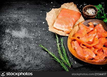 Salted salmon with rosemary, parsley and spices. On a black background. High quality photo. Salted salmon with rosemary, parsley and spices.