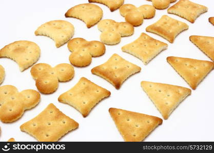 Salty crackers of the various geometrical form lie on a white background