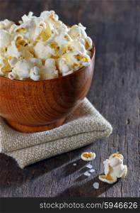 Salty popcorn on wooden table