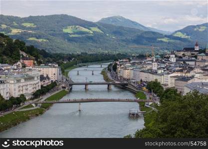 SALZBURG, AUSTRIA - JULY 9, 2016: Tourists walking on bridges along historical city center of Salzburg.