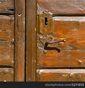 samarate abstract rusty brass brown knocker in a door curch closed wood lombardy italy varese
