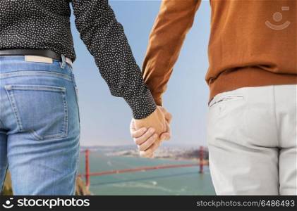 same-sex relationships, lgbt and homosexual concept - close up of male gay couple holding hands over golden gate bridge in san francisco bay background. close up of male gay couple holding hands. close up of male gay couple holding hands