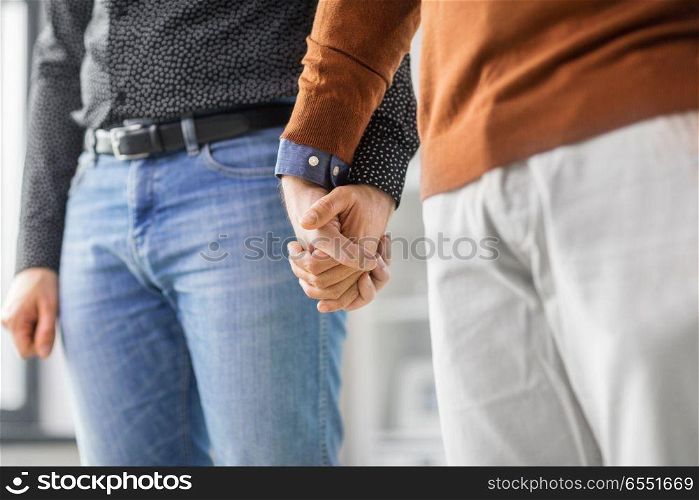 same-sex relationships, lgbt and homosexual concept - close up of male gay couple holding hands. close up of male gay couple holding hands. close up of male gay couple holding hands