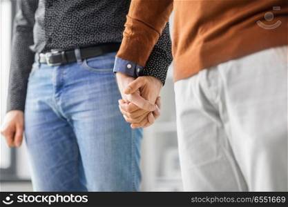 same-sex relationships, lgbt and homosexual concept - close up of male gay couple holding hands. close up of male gay couple holding hands. close up of male gay couple holding hands