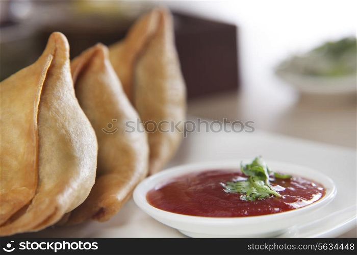 Samosa served with tomato ketchup in plate