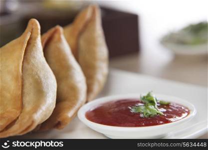 Samosa served with tomato ketchup in plate