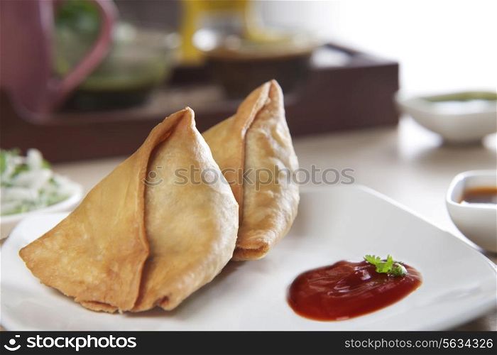 Samosas with tomato ketchup in plate