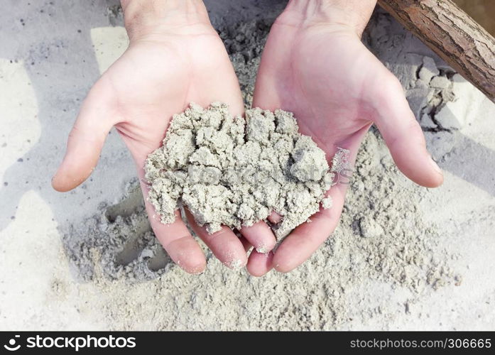 Sample of wet white quartz sand in male hands closeup. Selective focus, unrecognizable person.. White Quartz Sand In The Hands