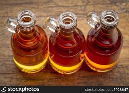 sampler of pure maple syrup. sampler of pure maple syrup (golden, amber and gold) - small glass bottles against rustic wood