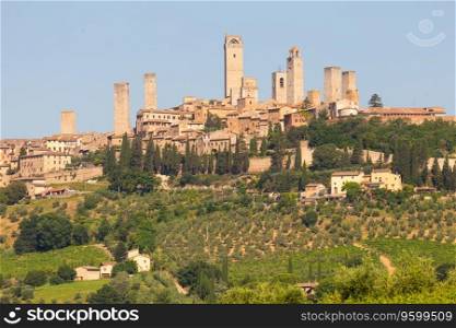 San Gimignano village, Italy - green countryside, blue sky, hill panorama with town and towers
