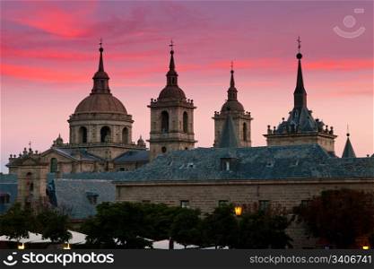 San Lorenzo de El Escorial Monastery with beautiful sky right after sunset. Four towers are set off by sky with pink and purple hues.