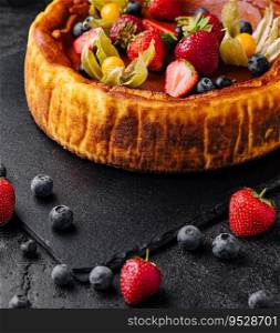 San Sebastian cheesecake with berries on black plate