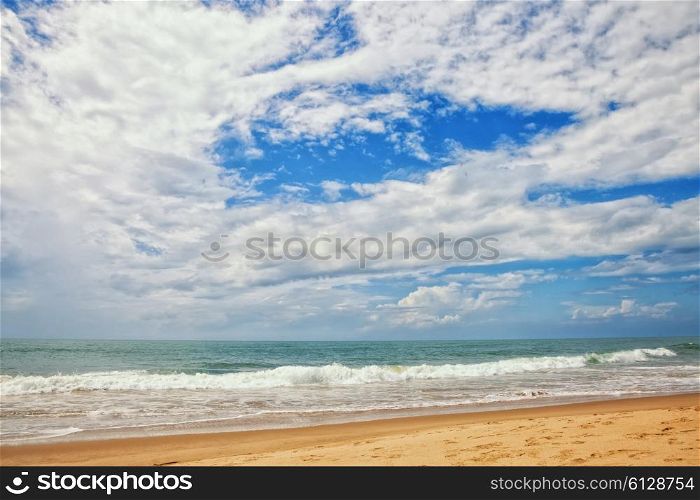 Sand beach, ocean and cloudy sky