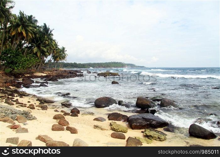 Sand beach with rocks near Dondra lighthouse, Sri Lanka
