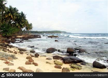 Sand beach with rocks near Dondra lighthouse, Sri Lanka