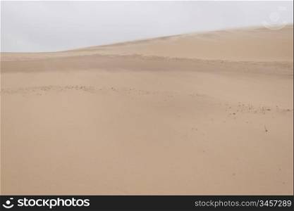 Sand blowing over sand dune. Sand blowing over sand dune in wind on a stormy day