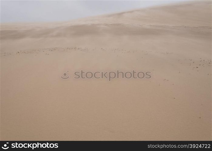 Sand blowing over sand dune. Sand blowing over sand dune in wind on a stormy day