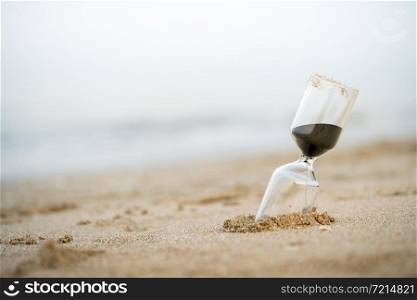 Sand clock on the beach, business time management concept