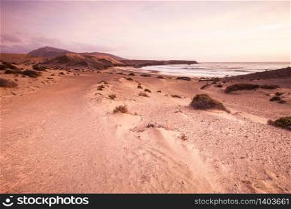 Sand desert dunes and sea beach landscape at sunrise