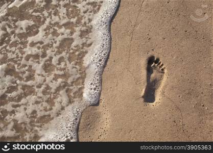 sand with footprint and water wave