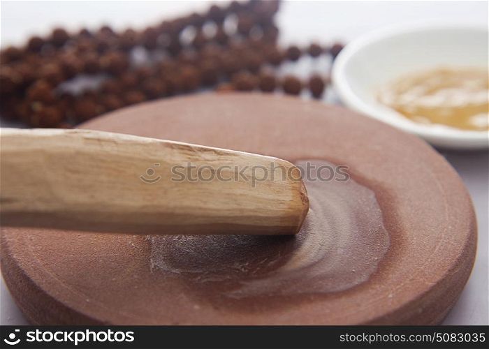 Sandalwood stick with stone grinder,sandalwood paste in a bowl and mala
