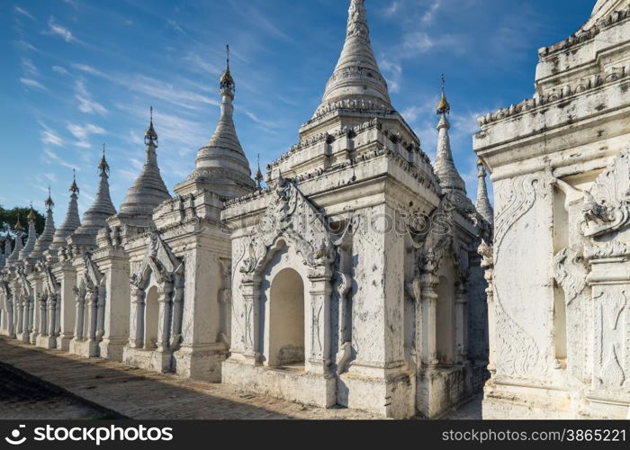 Sandamuni Pagoda with row of white pagodas. Amazing architecture of Buddhist Temples at Mandalay. Myanmar (Burma) travel landscapes and destinations