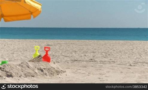 Sandburg mit Spielzeug und Sonnenschirm am South Beach - umbrella with toys on South Beach Miami