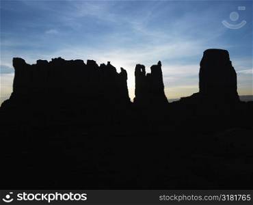 Sandstone mesas and buttes silhouetted in Monument Valley.