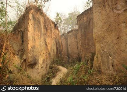 sandstone or limestone canyon walls seen from the canyon floor at an eroded land split in Northern Thailand, Southeast Asia. sandstone or limestone canyon walls seen from the canyon floor at an eroded land split in Northern Thailand, Southeast Asiasandstone or limestone canyon walls seen from the canyon floor at an eroded land split in Northern Thailand, Southeast Asia