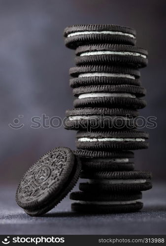 Sandwich cookie consisting of two chocolate wafers with cream filling with on stone board.