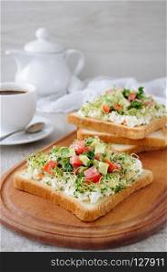 Sandwich for breakfast from tender, juicy germinated alfalfa sprouts with soft ricotta, tomato and avocado slices, with a cup of coffee or tea, which may be better for a break